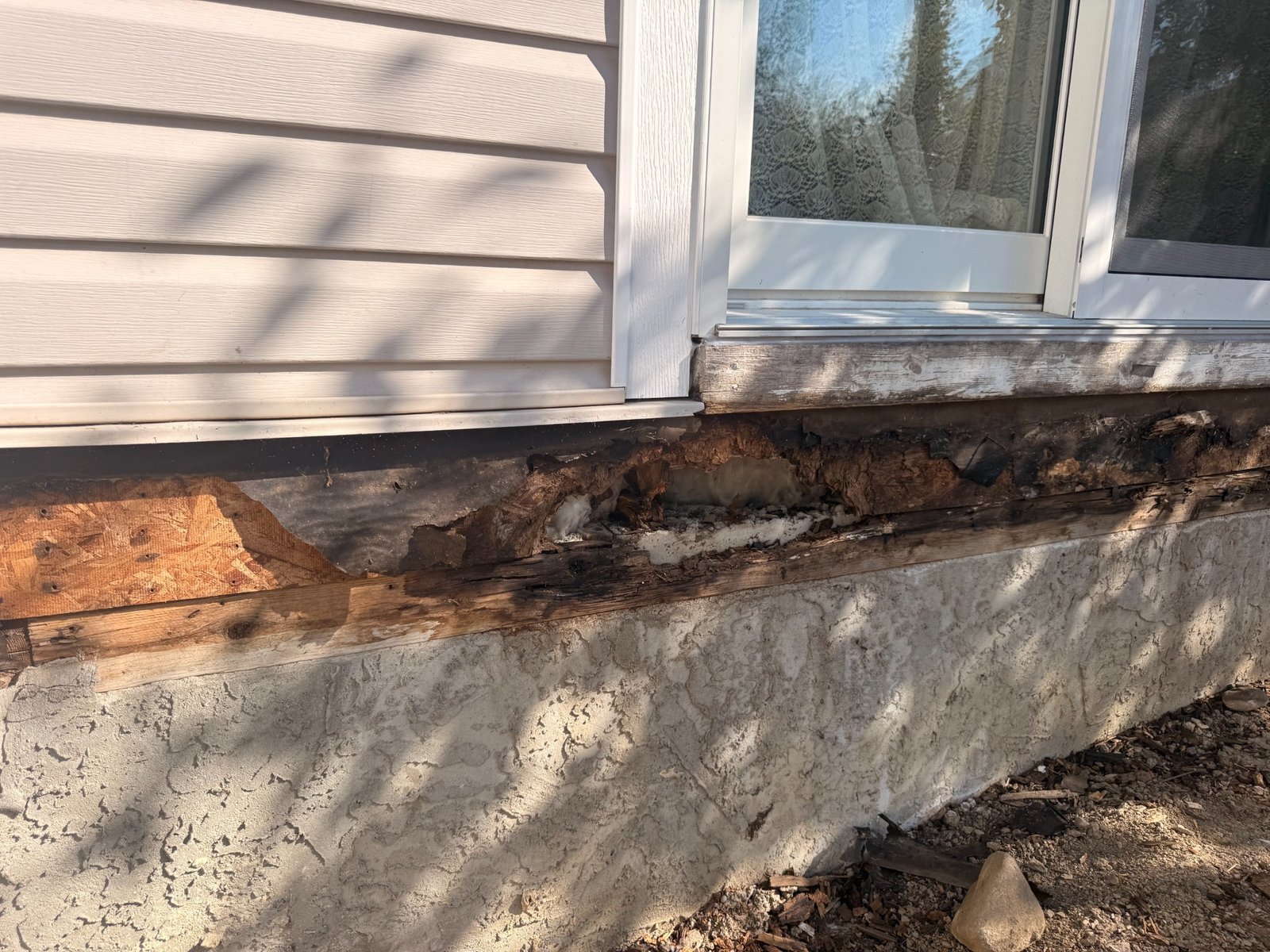 Wide view of deck rot damage at exterior wall